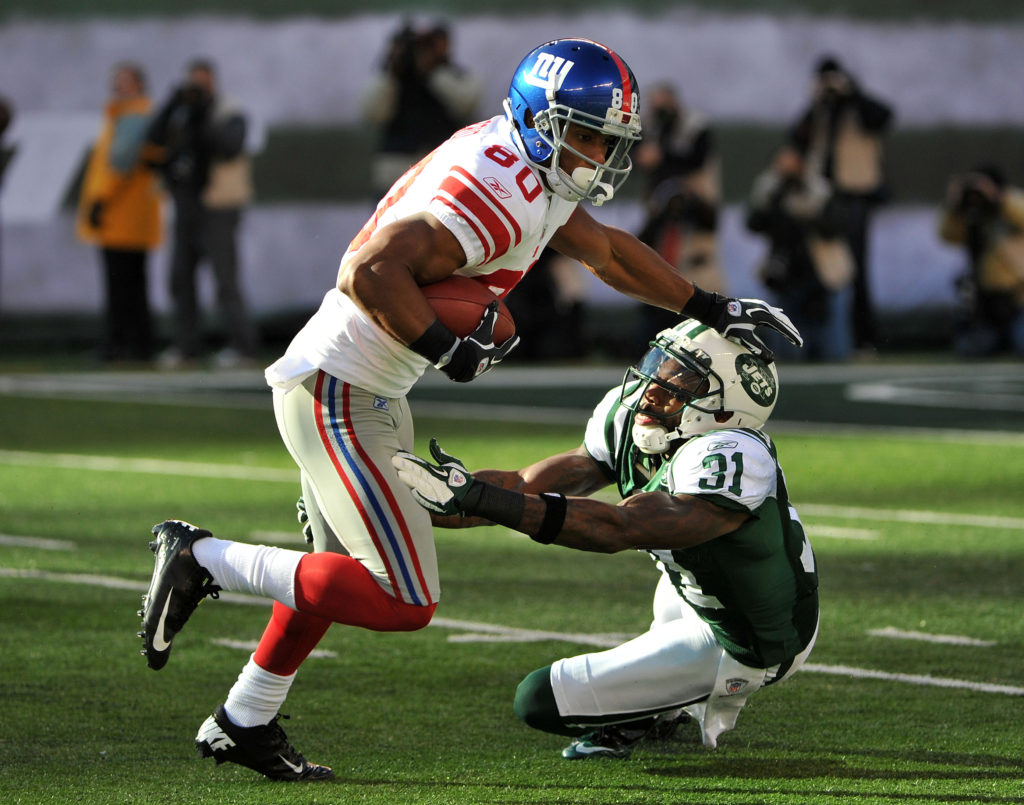 EAST RUTHERFORD, NJ - DECEMBER 24: Victor Cruz #80 of the New York Giants breaks the tackle attempt of Antonio Cromartie #31 of the New York Jets during the first half on December 24, 2011 at MetLife Stadium in East Rutherford, New Jersey. (Photo by Christopher Pasatieri/Getty Images)